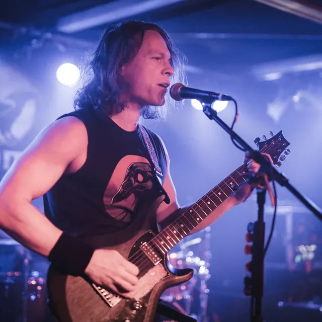 Markus singt und spielt Gitarre im blauen Bühnenlicht, Raue Nacht im November 2025